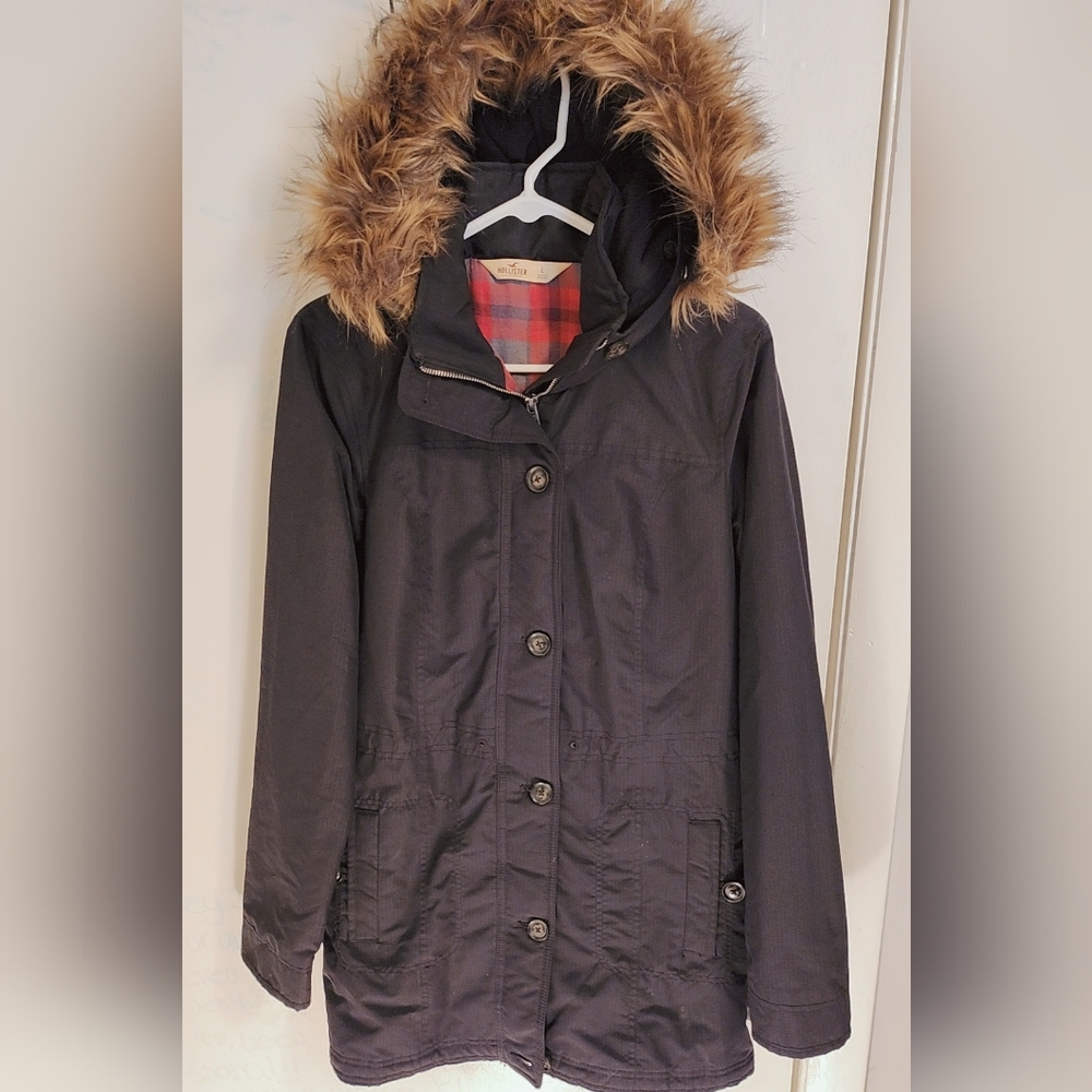 Hollister women's hooded parka jacket with faux fur trim and a red plaid lining.